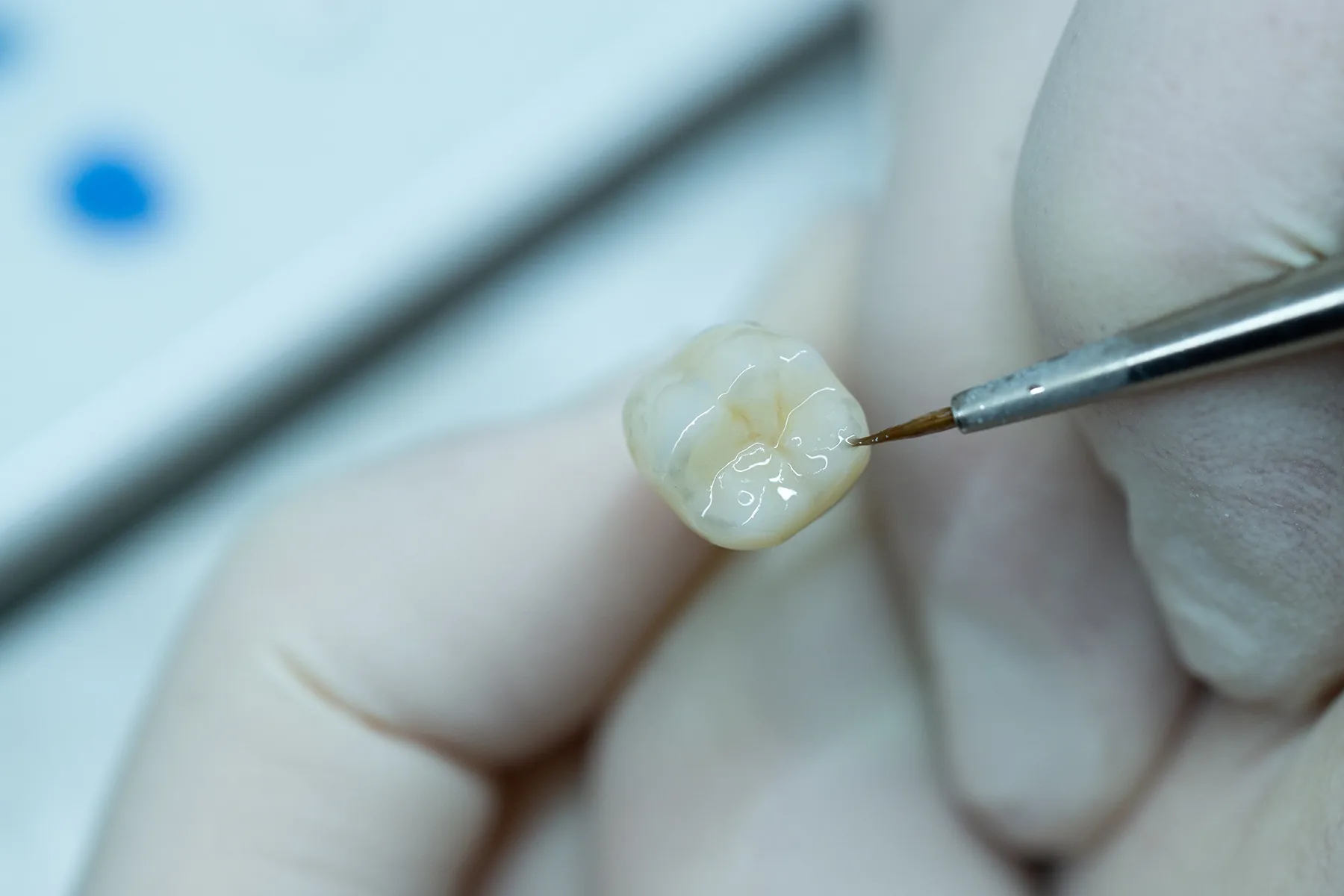 Una corona posteriore tenuta tra le dita guantate, durante la rifinitura